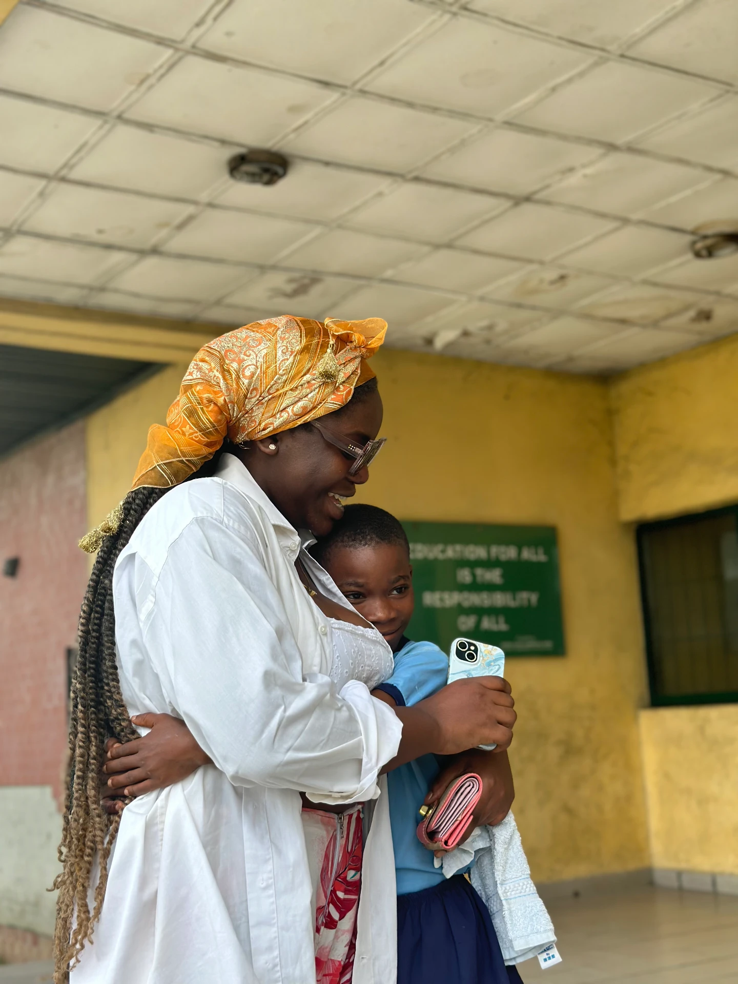 Ibi Kontein embracing a child during a school visit in Port Harcourt